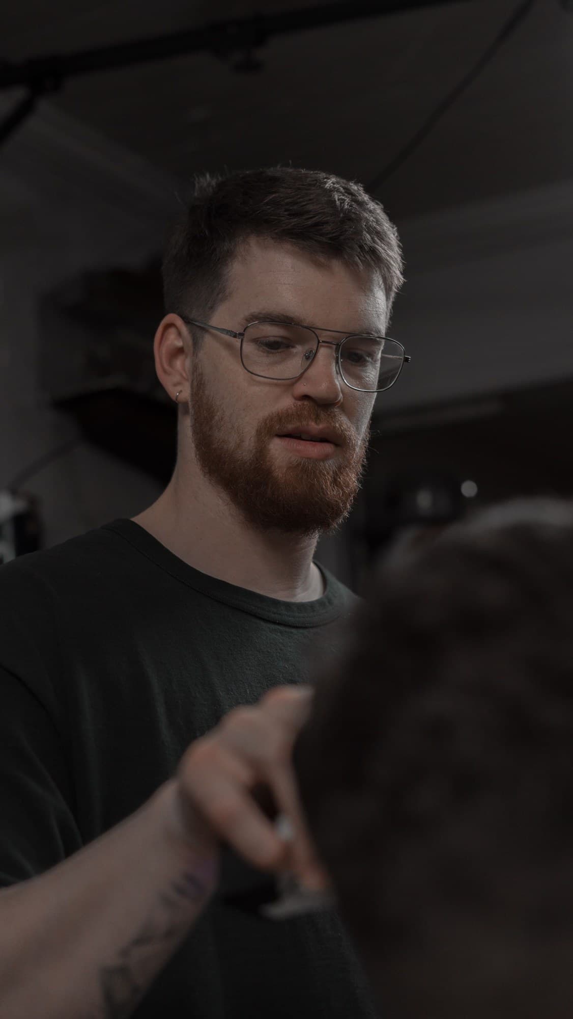 Tristun Fife (Fifi / FifiMetaX) in glasses, cutting a client's hair
